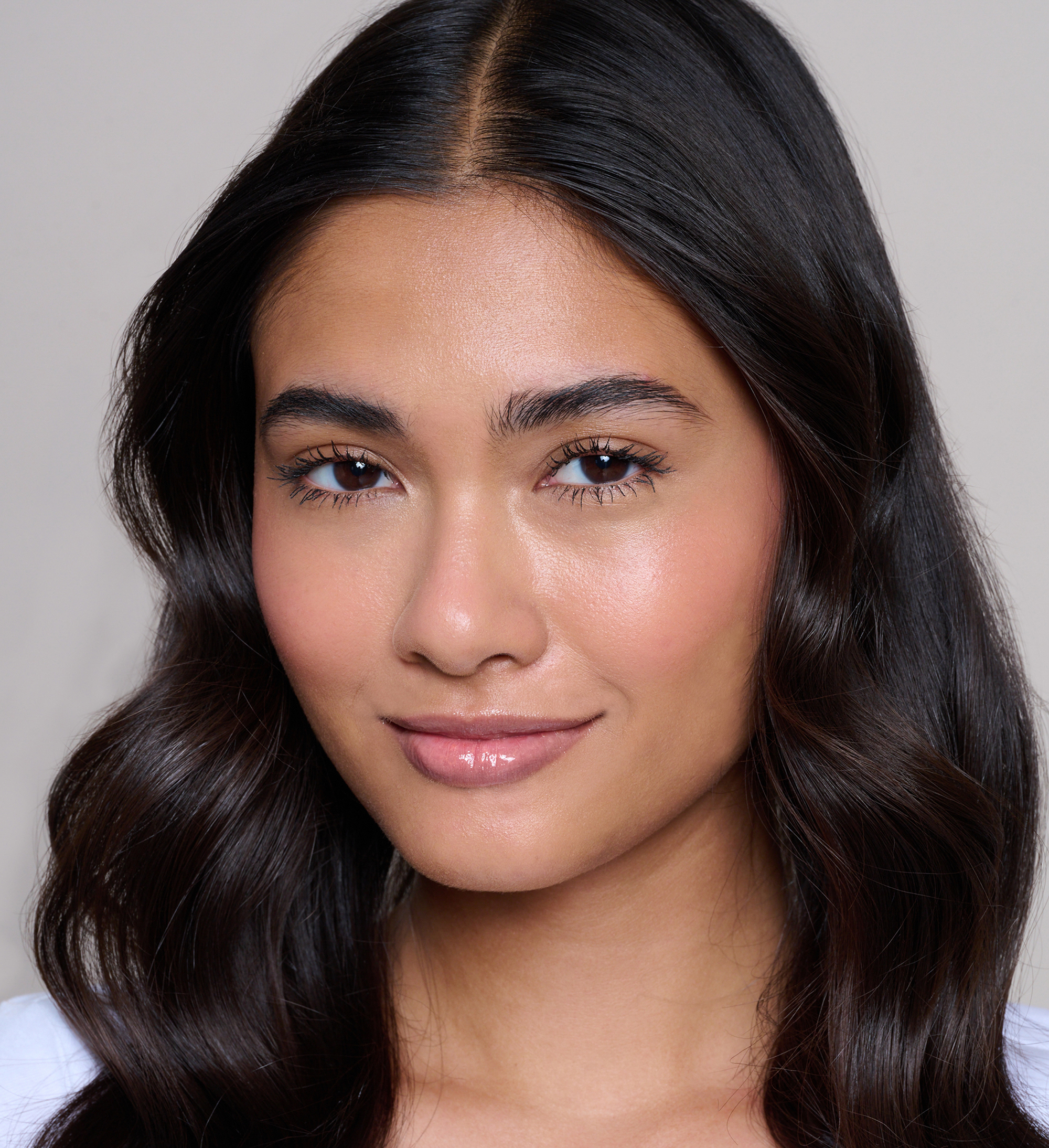 Model wearing Skin Loving BB Cream, Feature Length Lash Lover mascara, Cheek Veil Liquid Blush in Splendour and Beautifying Brow Wand