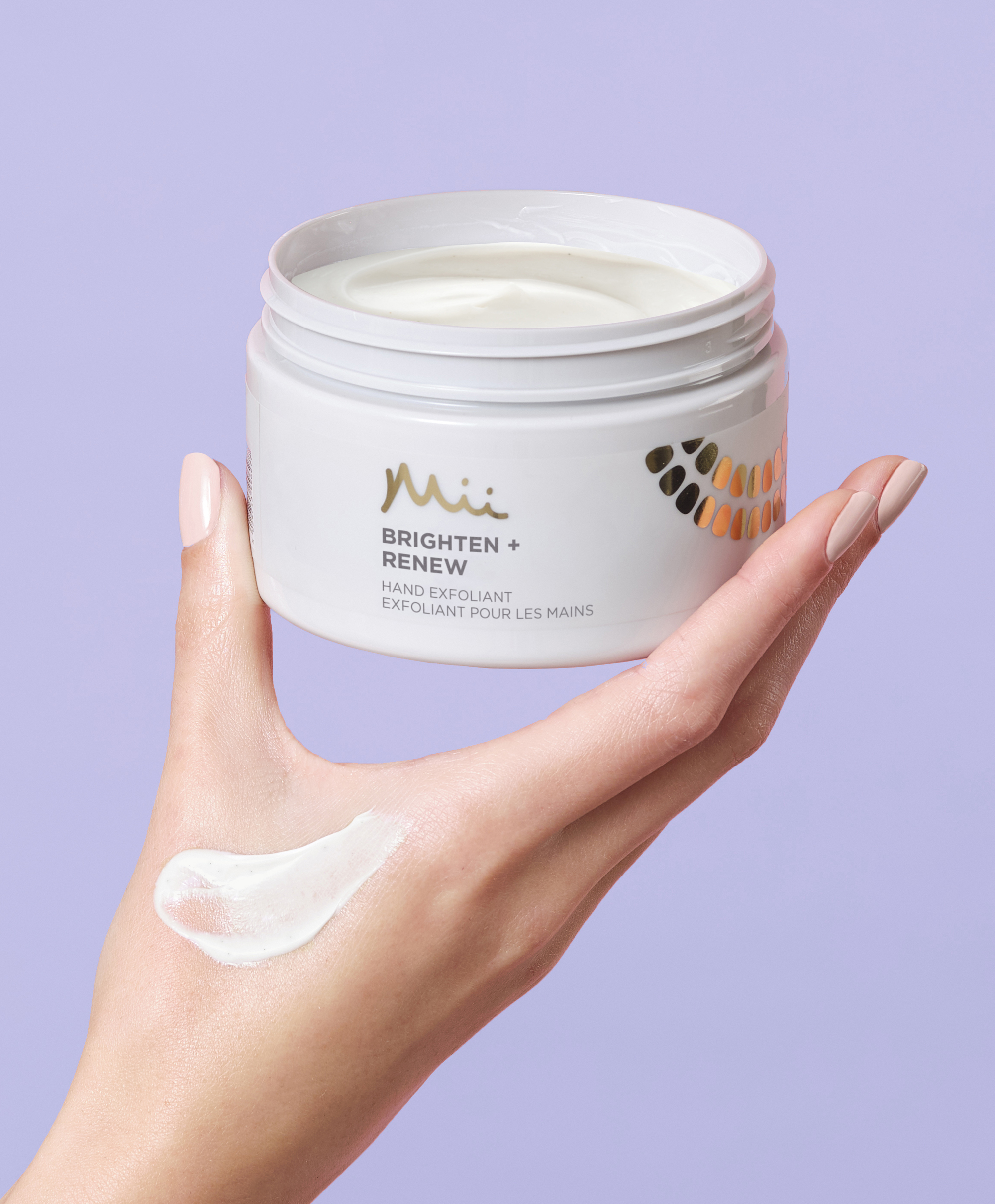 Model holding Brighten + Renew Hand Exfoliant