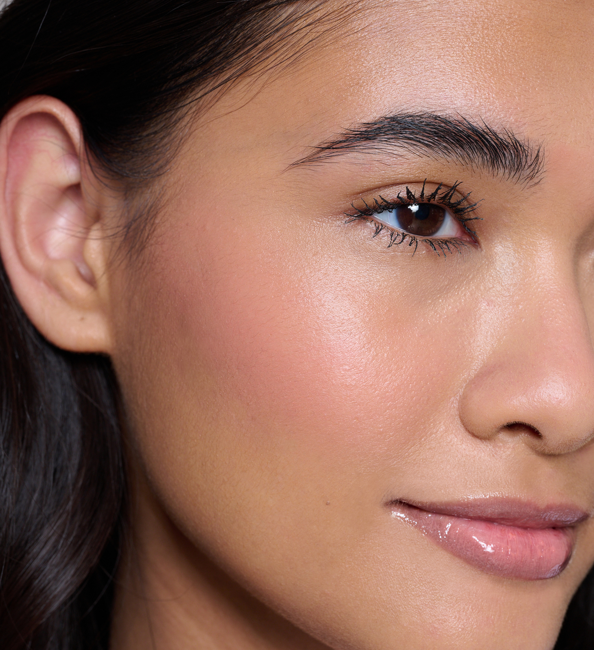 Model wearing Skin Loving BB Cream, Feature Length Lash Lover mascara, Cheek Veil Liquid Blush in Splendour and Beautifying Brow Wand