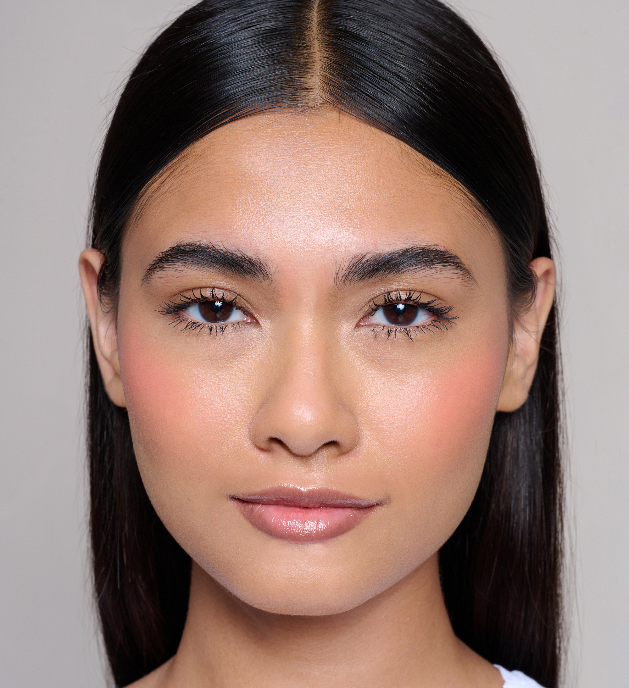 Model wearing Skin Loving BB Cream, Feature Length Lash Lover mascara, Cheek Veil Liquid Blush in Radiance and Beautifying Brow Wand