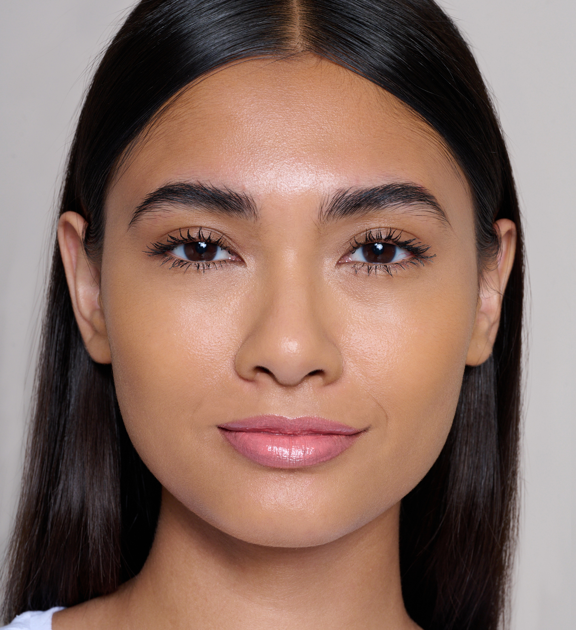 Model wearing Skin Loving BB Cream, Feature Length Lash Lover Mascara and Lavish Lip Creme Lip Gloss Illicit