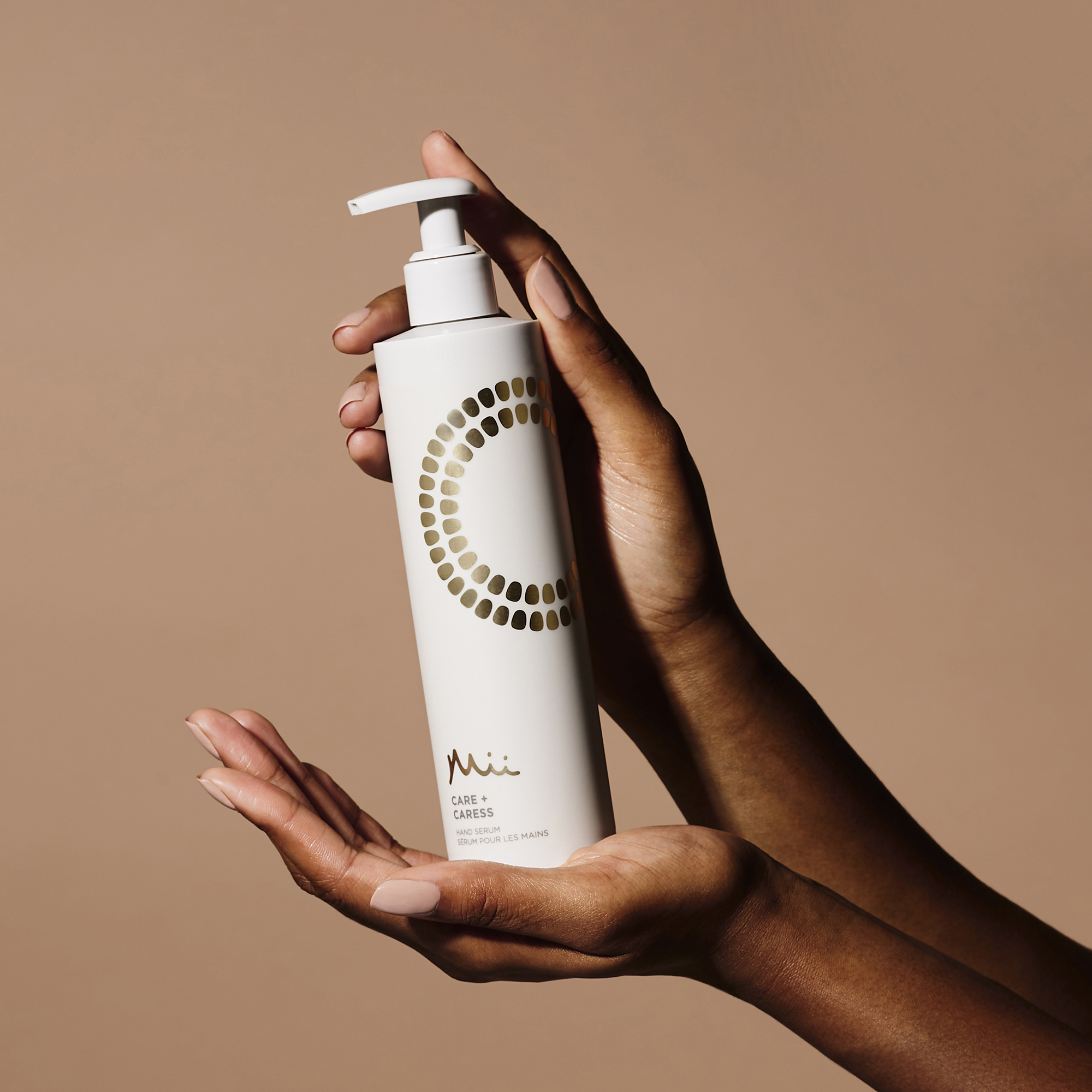 Model holding Care + Caress Hand Serum