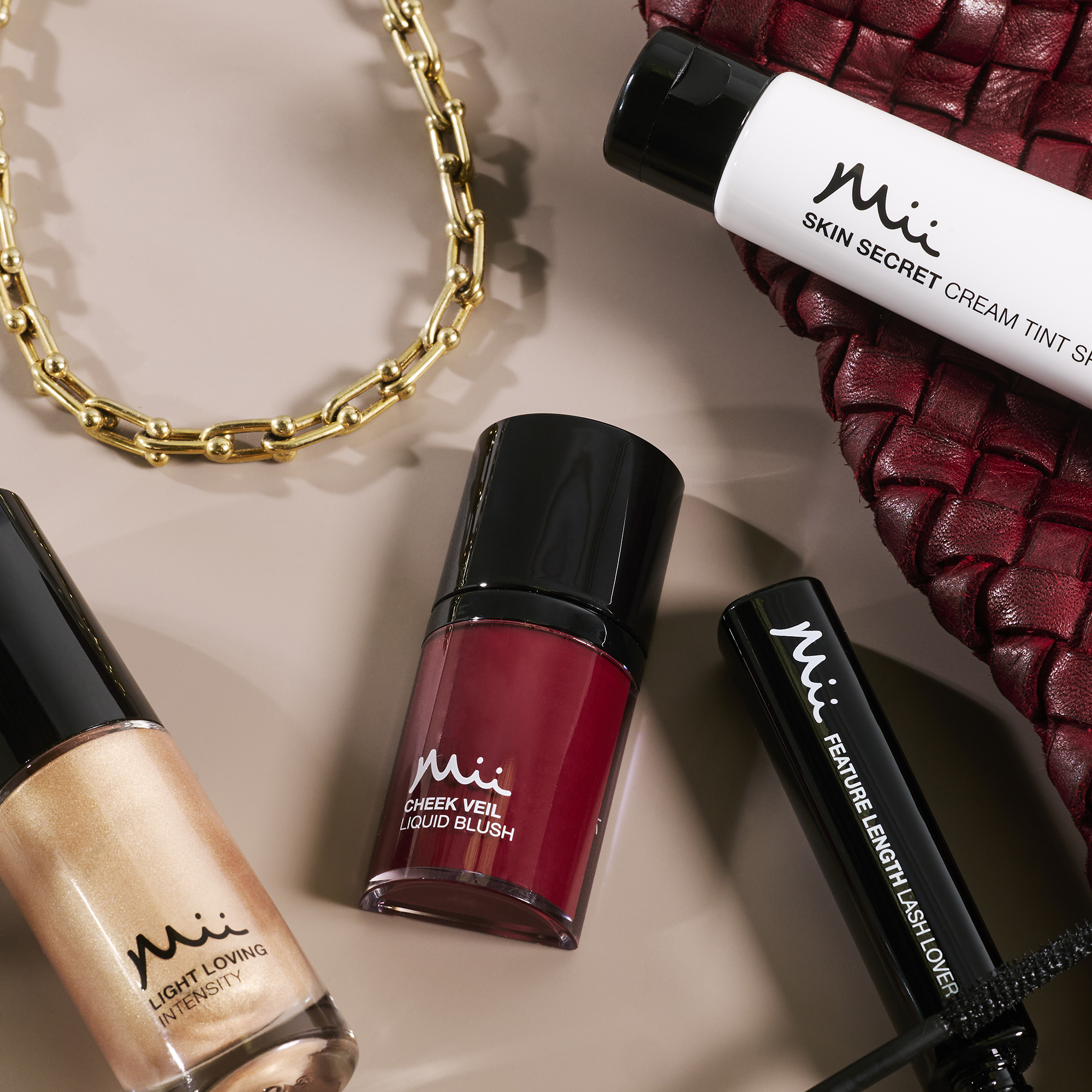 Group stylised shot of Light Loving Intensity Liquid Highlighter, Cheek Veil Liquid Blush in Ravishing, Skin Secret Cream Tint and Feature Length Lash Lover Mascara