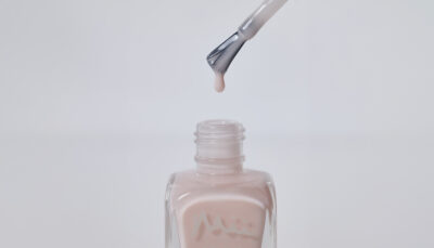Open bottle of Hopeful Blush Colour Confidence Nail Polish with brush dripping nail polish back into the bottle