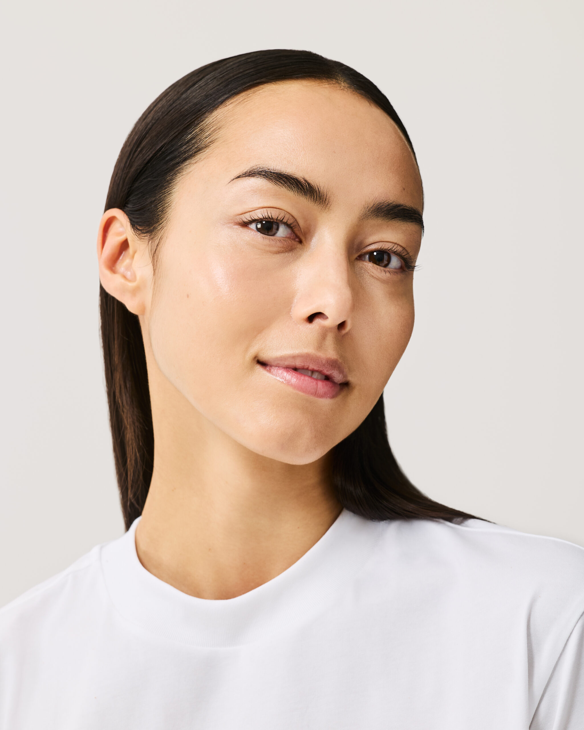 Model wearing Skin Perfecting Concealer in shade 7 against a neutral background