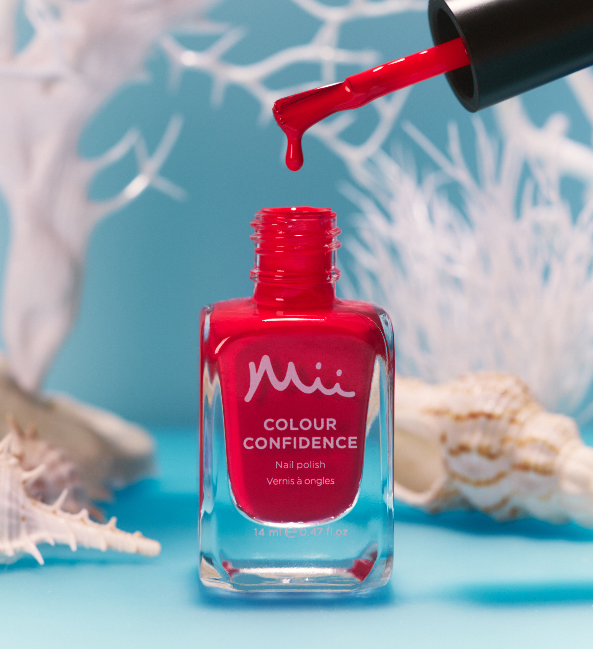 Dripping shot of Blaze Colour Confidence Nail Polish against a blue background with white plants