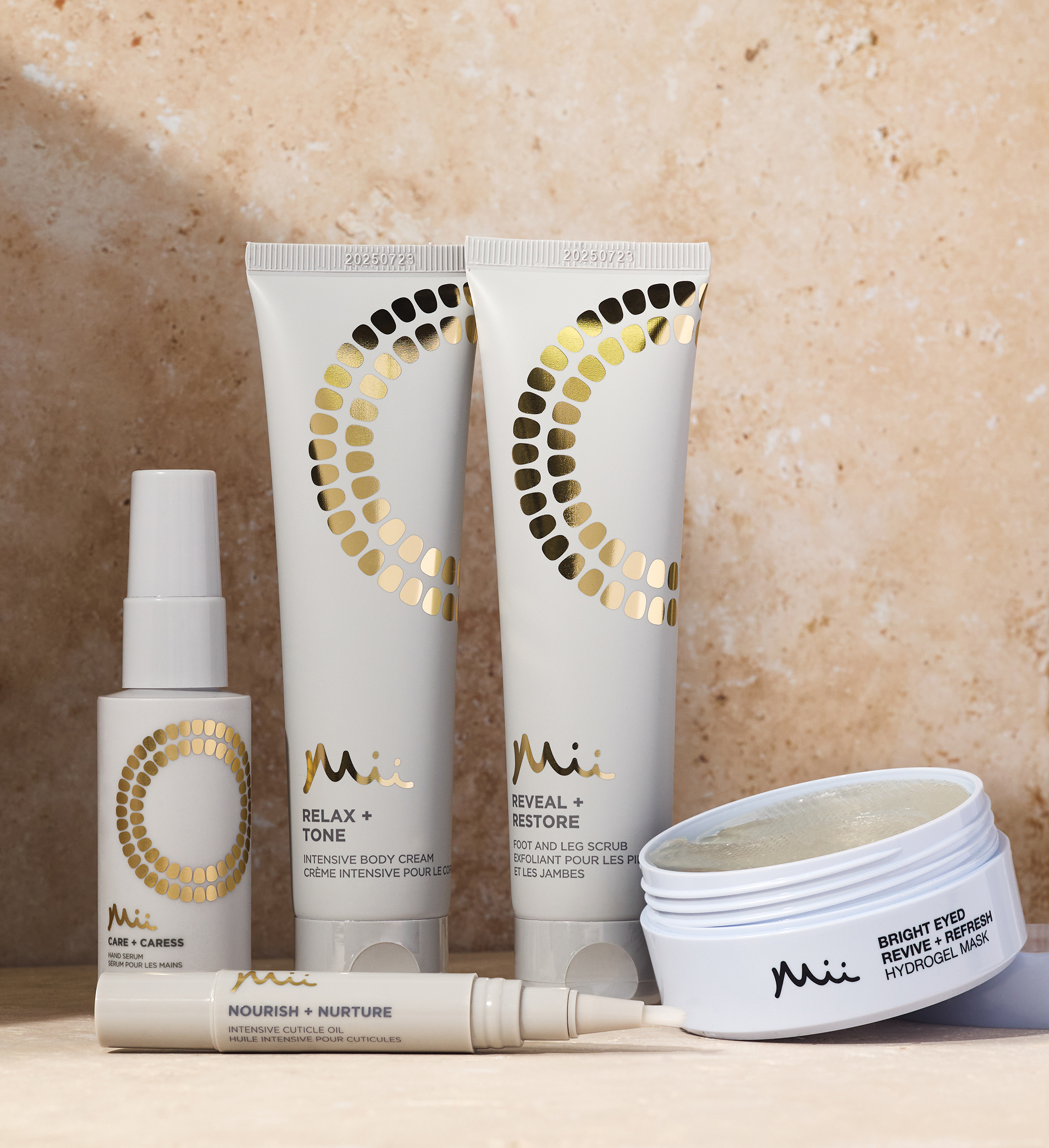 Pedicure products group shot against a marble background - Refresh + Revive Foot Spritz 50ml, Nourish + Nurture Cuticle Oil Pen, Bright Eyed Revive + Refresh Hydrogel Mask and Reveal + Restore Foot Scrub 100ml