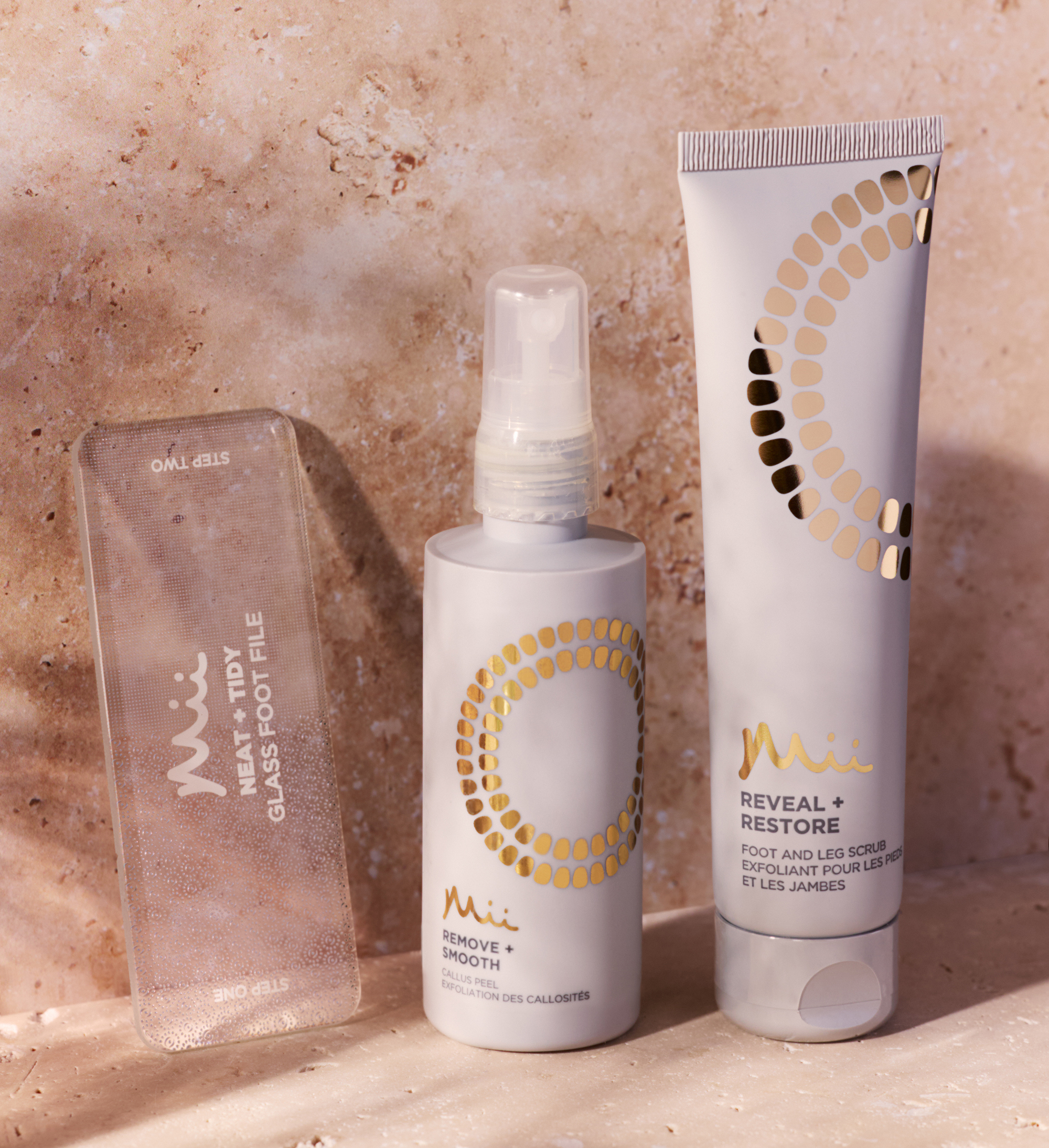 Neat + Tidy Glass Foot File, Reveal + Restore Foot Scrub 100ml and Remove + Smooth Callus Peel 100ml against a marble background