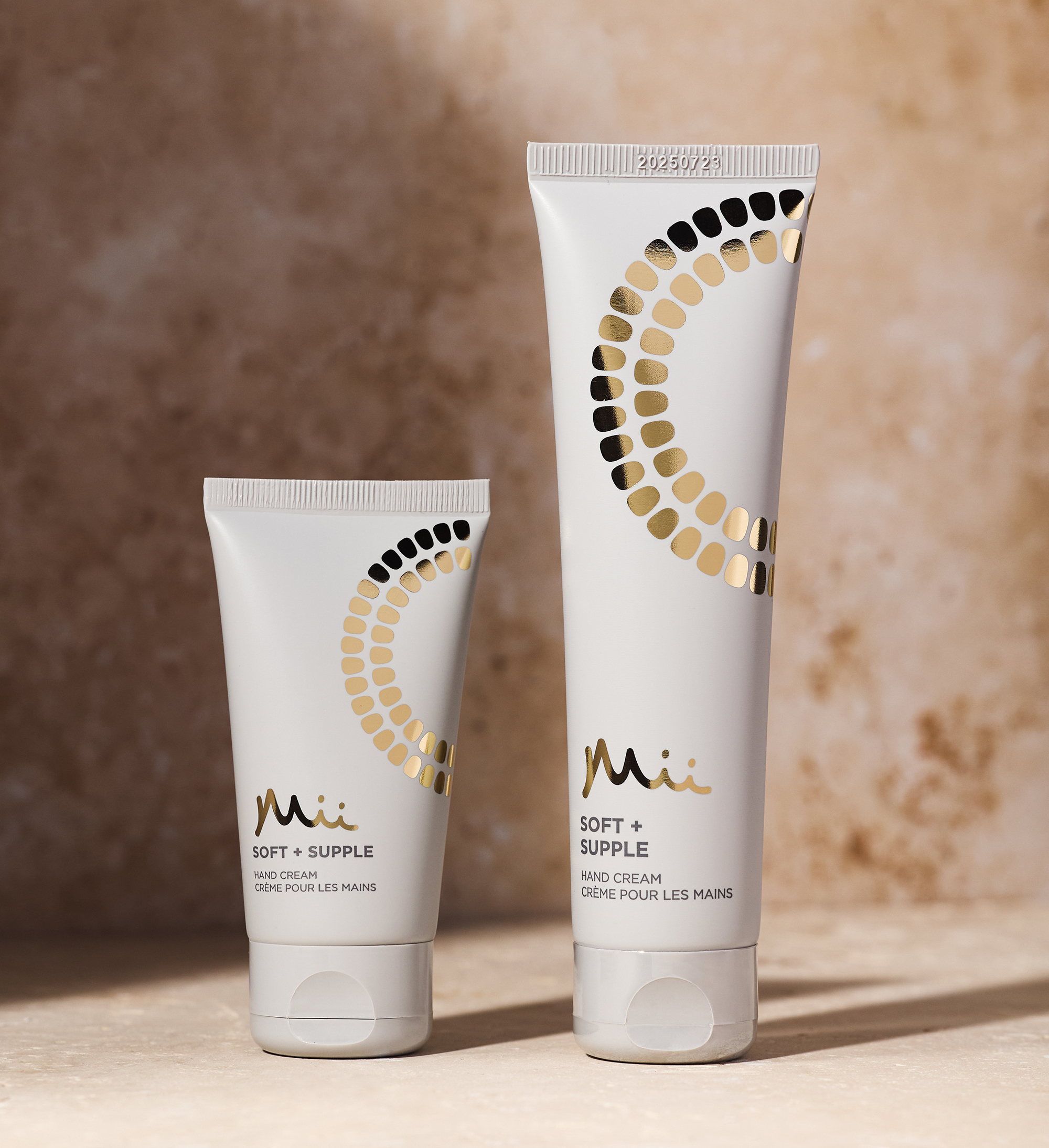 Soft + Supple Hand Cream 50ml and 100ml against a marble background